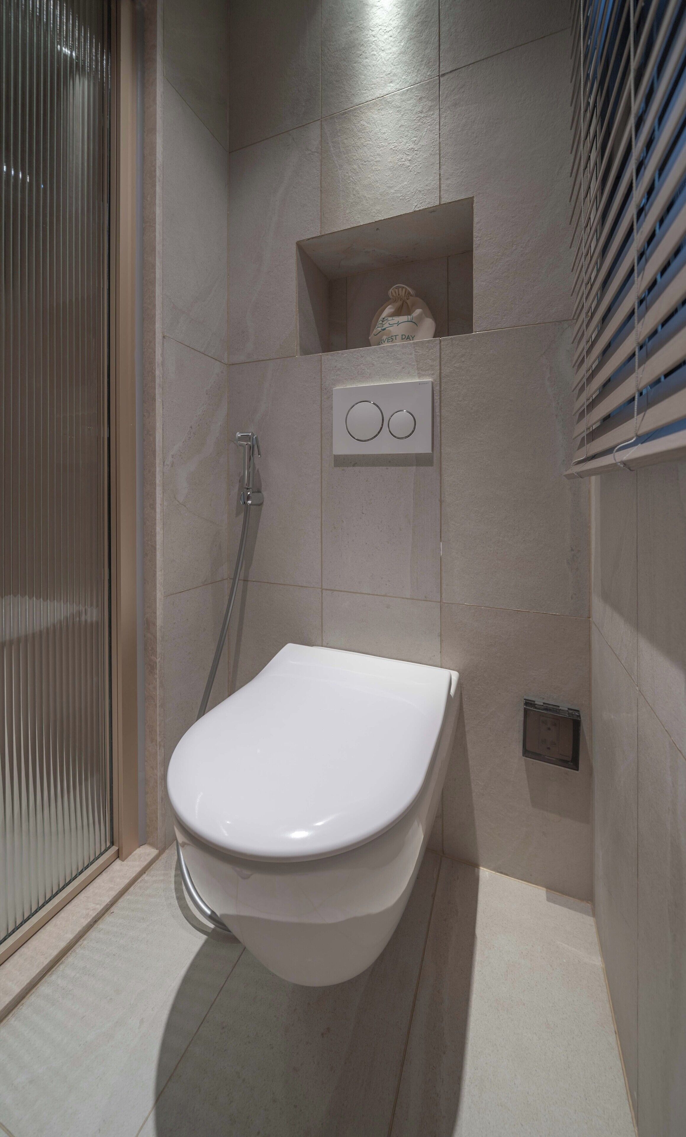 A modern bathroom with a toilet, a shower, and a towel rack.