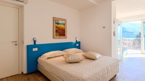 A bedroom with a bed, a painting, and a view of the outdoors. - Cosy apartment for 3 guests with WIFI, A/C, TV and terrace (Gravedona)