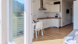 A modern kitchen with white cabinets, a wooden countertop, and a built-in microwave. - Cosy apartment for 3 guests with WIFI, A/C, TV and terrace (Gravedona)