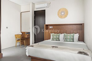 A hotel room with a bed, a desk, and a chair.