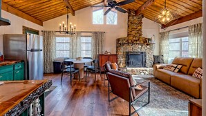 A spacious living area with a stone fireplace, wooden ceiling beams, and a cozy seating arrangement. - Chaco`s Chalet Cabin in the Smokies (Franklin)