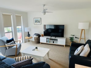 A living room with a sofa, a coffee table, a TV, and a floor lamp.