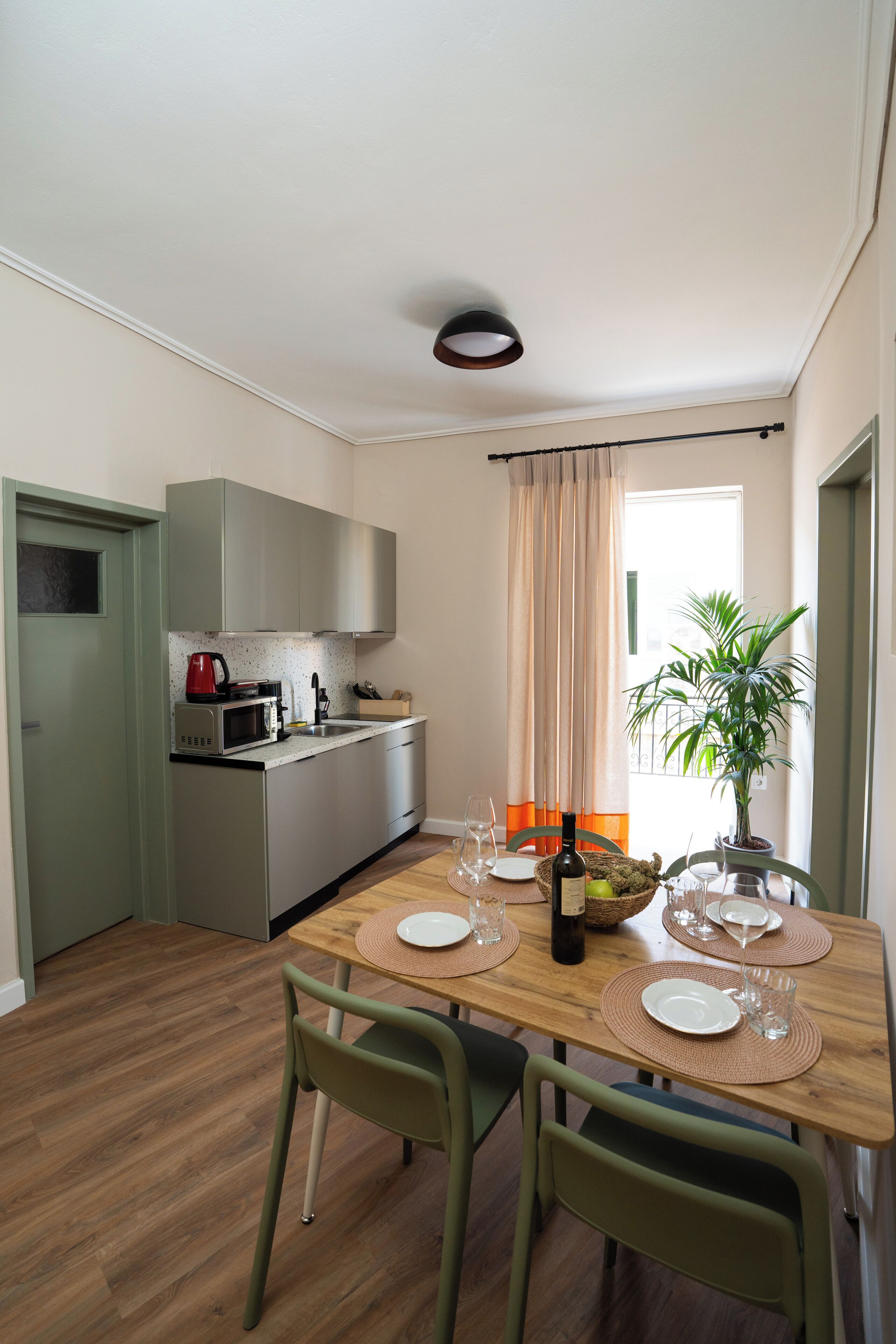Una cocina compacta con electrodomésticos modernos y un comedor con una mesa y sillas de madera.