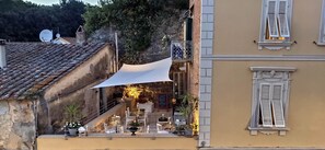 A terrace with outdoor seating, a stone wall, and a decorative balcony railing. - Residenza d'Epoca CAVALIERE (Bibbona)