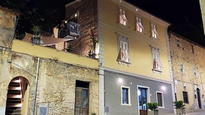 A multi-story building with a stone facade, balconies, and a staircase leading to an upper level. - Residenza d'Epoca CAVALIERE (Bibbona)