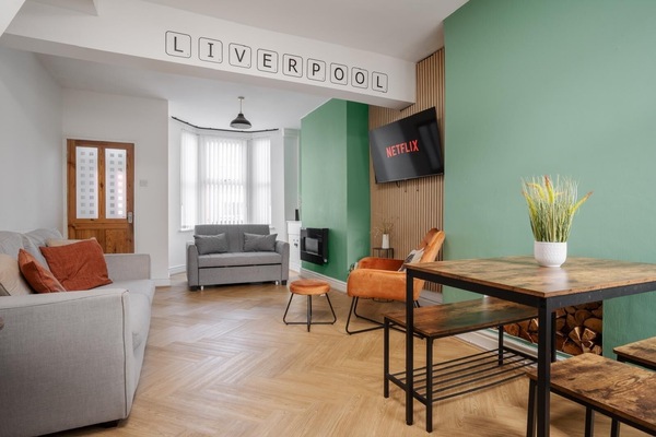 The comfortable living space includes a Smart TV with Netflix, a sofa bed for additional sleeping space, and a chair with an ottoman set—perfect for relaxing after a long day.