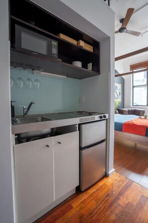 A compact kitchen with a built-in oven, a microwave, and a sink. - Cosy CBD Loft Walk to Dining+Shopping Zodiak Stays (Auckland)