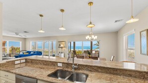 A spacious kitchen with granite countertops, stainless steel sink, and pendant lighting. - 390 Gulf - Beachfront, 4 bed - 4 bath Private Pool - Dog Friendly! (Boca Grande)