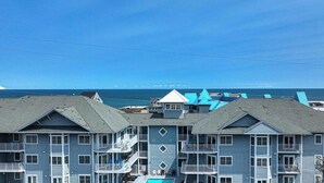 Ein Hotel direkt am Strand mit mehrstöckigen Gebäuden, Balkonen und einem Swimmingpool.