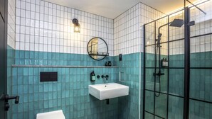A bathroom with a white toilet, a sink, and a glass-enclosed shower.