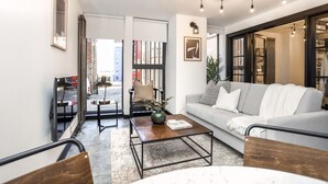 A modern living room with a sofa, coffee table, and a bookshelf.