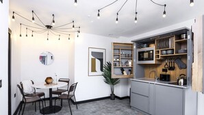 A compact kitchen with grey cabinets, a built-in microwave, and a hanging pot rack. - Laboratory Store: 2bed moments from Royal Mile (Edinburgh)