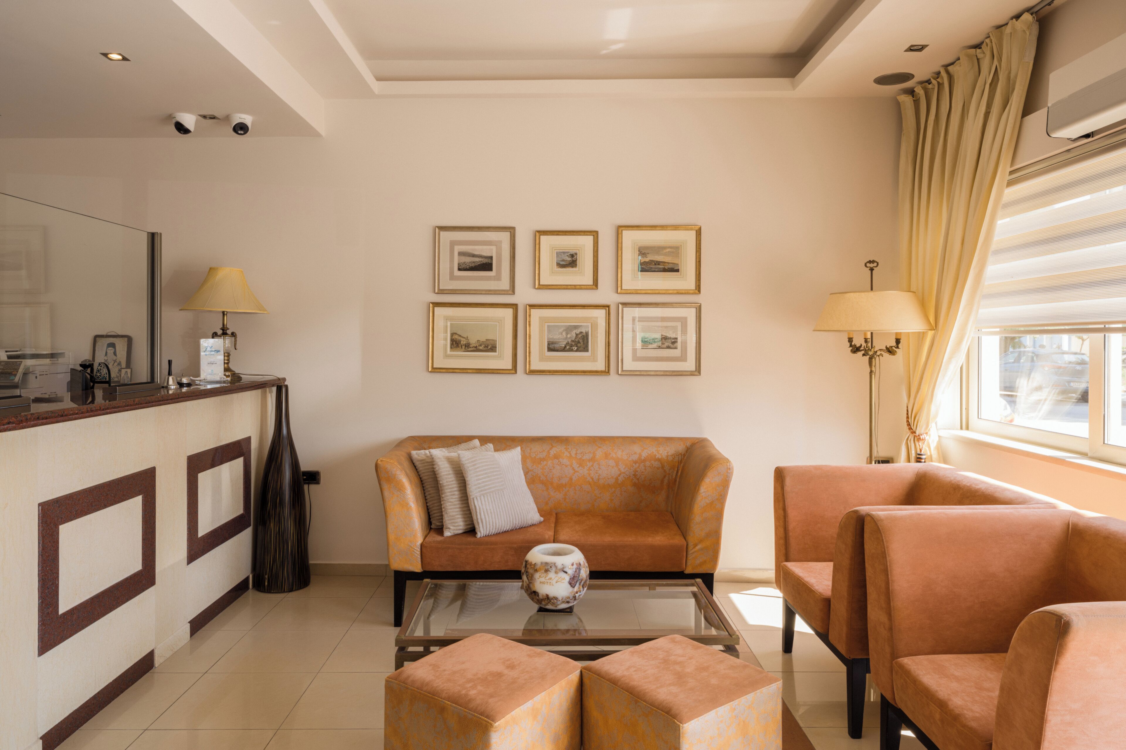 A living room with a sofa, armchairs, a coffee table, and framed pictures on the wall.
