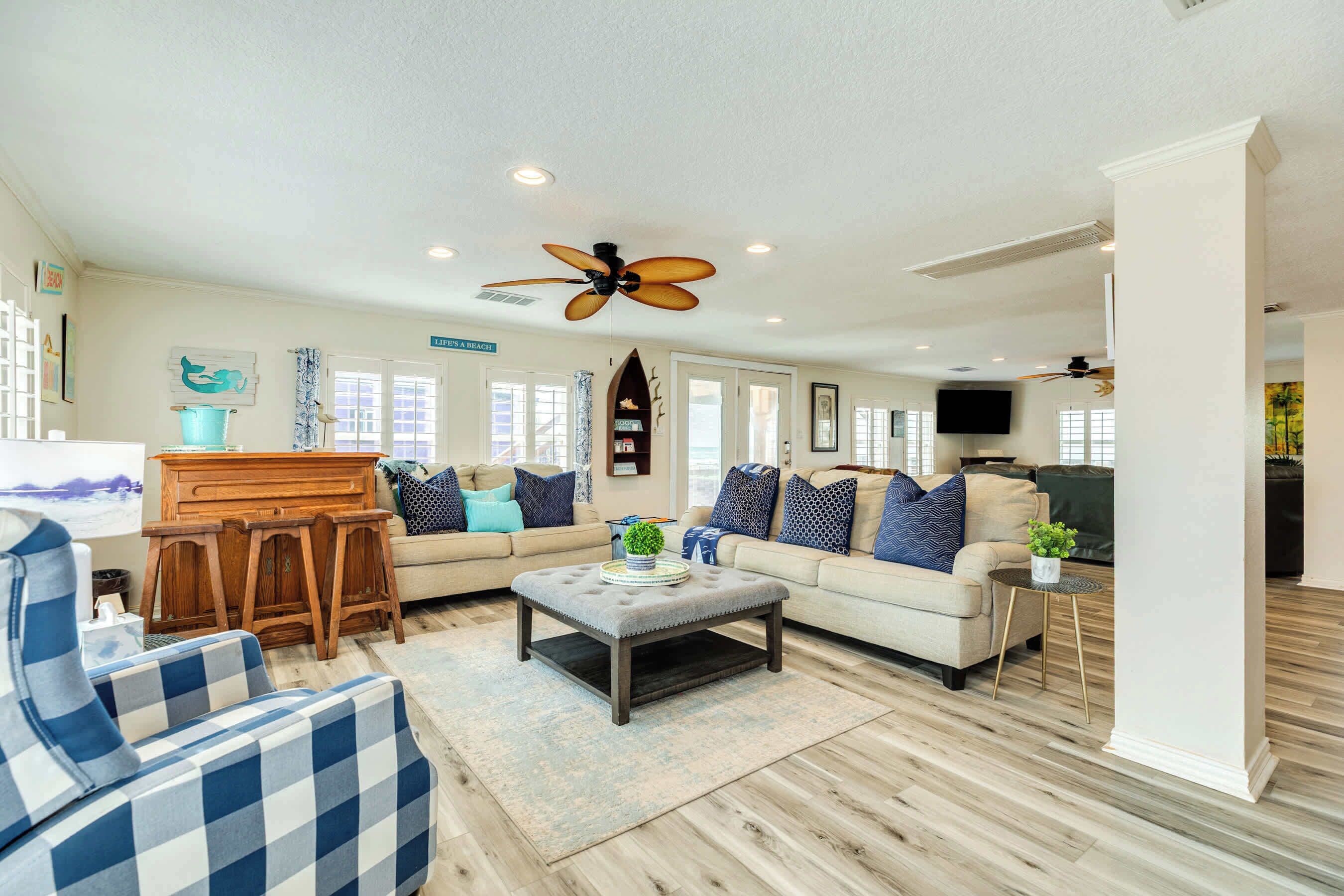 A spacious living room with a large sofa, a coffee table, and a dining area.