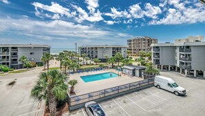 A hotel with a swimming pool, parking area, and ocean view. - Drifty Daze Oceanfront Suite w Pool (North Myrtle Beach)