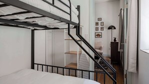 Habitación con literas y una escalera que lleva a un baño.
