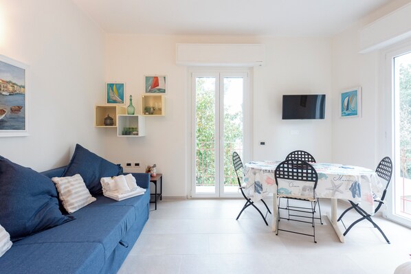 Appartement, 2 chambres, balcon | Coin séjour | Télévision à écran plat de 32 pouces avec chaînes par câble