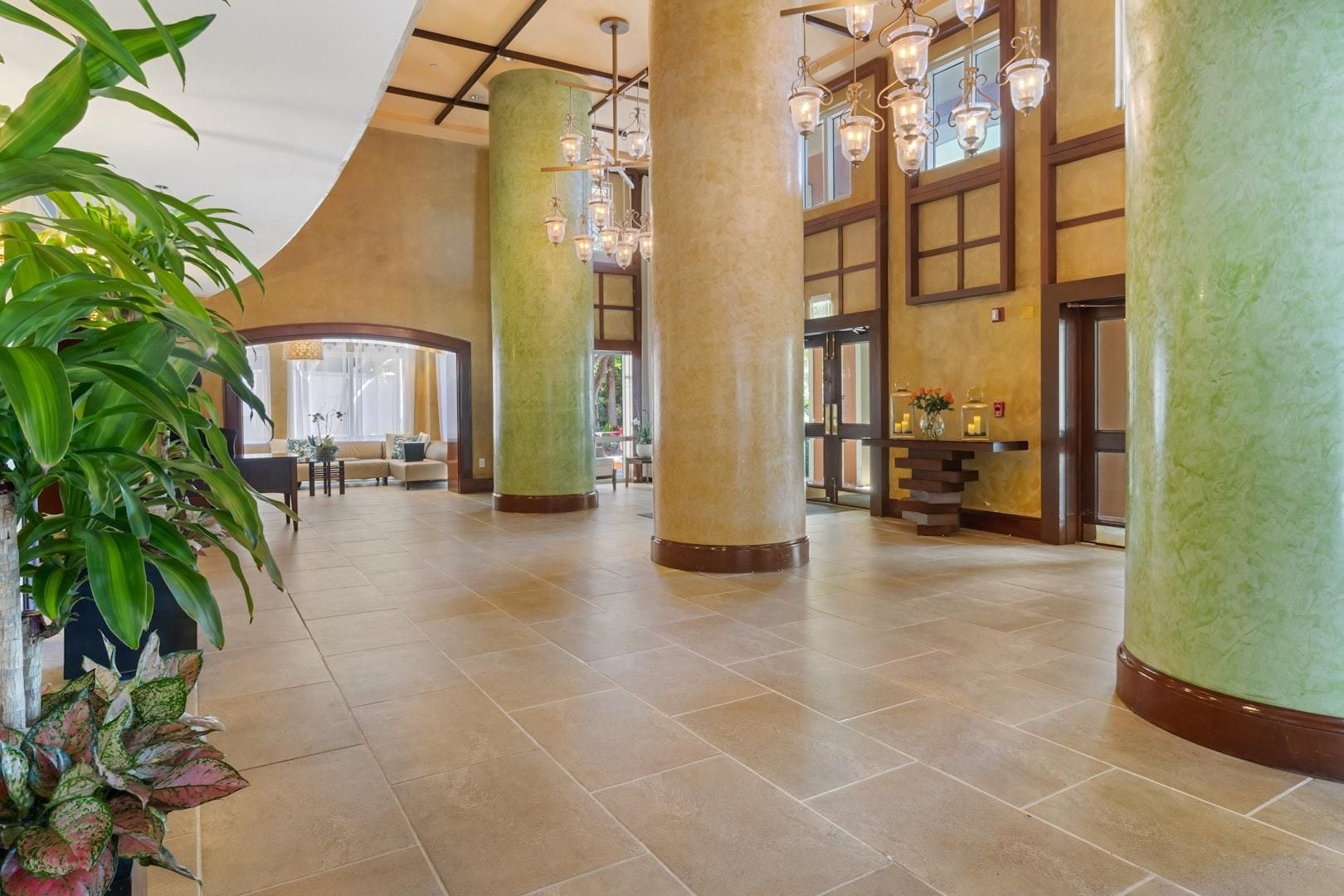 Un hall d’entrée spacieux, doté de hauts plafonds, de grandes colonnes et d’un lustre moderne.