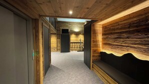 Un pasillo con paredes de madera y suelo alfombrado que conduce a una habitación con un esquí.