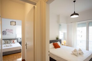 A hotel room with a bed, a nightstand, a lamp, and a window with curtains.