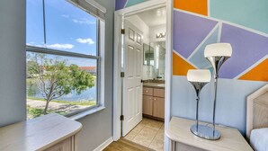 Une salle de bain moderne avec une grande fenêtre, un lavabo et un miroir.