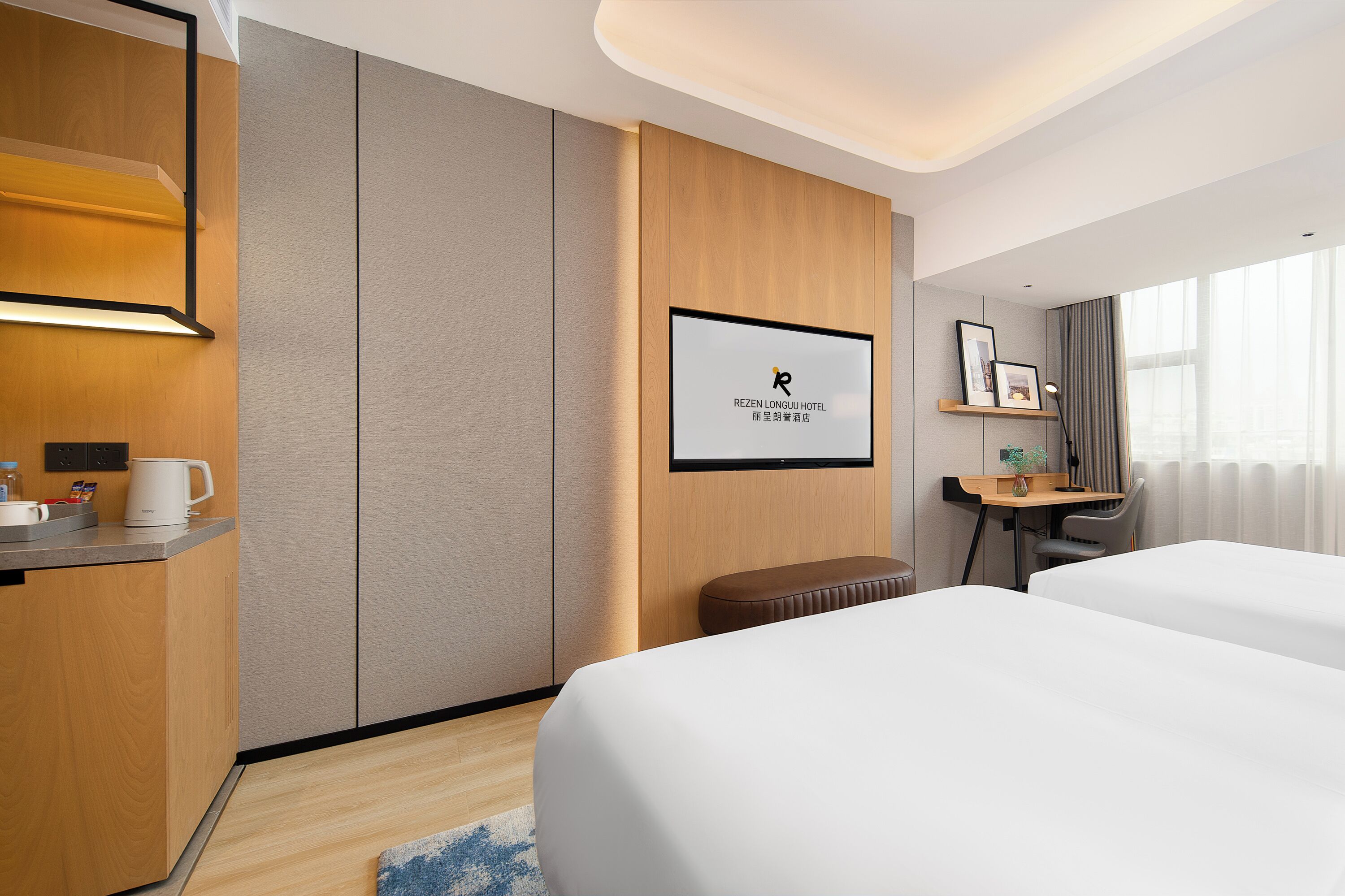 Une chambre d’hôtel avec deux lits, un bureau, une chaise, une petite table, une machine à café et un tableau encadré au mur.