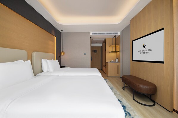 Habitación de hotel con dos camas, un banco, un televisor y una pared de madera.
