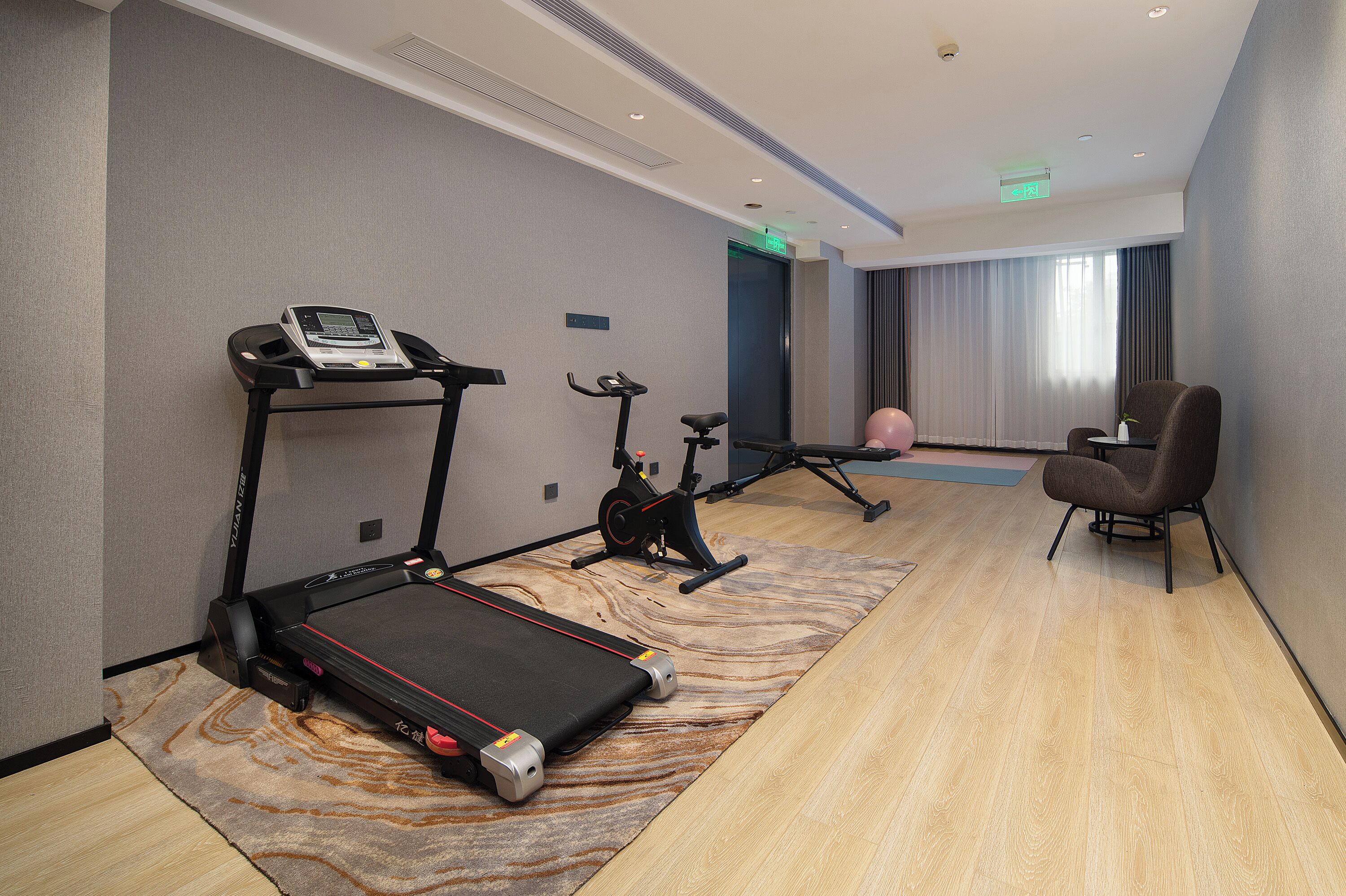 Ett hotellrum med löpband, motionscykel och en massageboll.