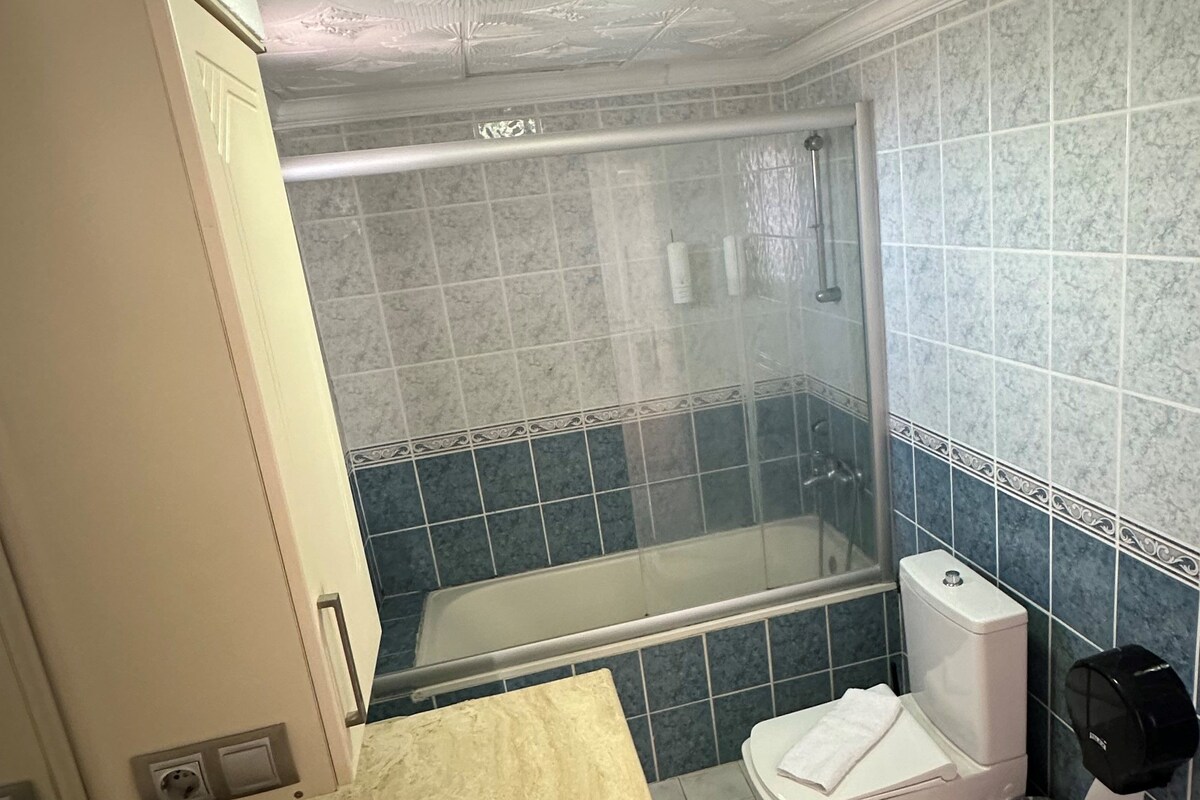 A bathroom with a shower, toilet, and sink.