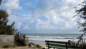 A bench by the beach with a view of the ocean.