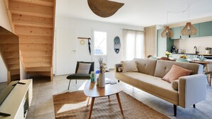 Een moderne woonkamer met een bank, salontafel en een trap.