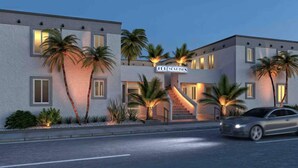 A modern hotel with a two-story structure, palm trees, and a car parked in front. - Spring break Retreat in Hollywood Beach (Hollywood)