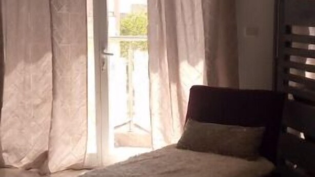 Una camera da letto con un letto, tende e vista all'esterno.