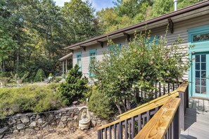 A wooden deck with a stone wall and a statue.