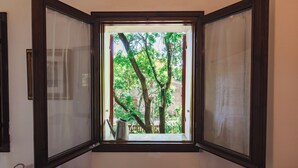 A room with a window overlooking a garden.