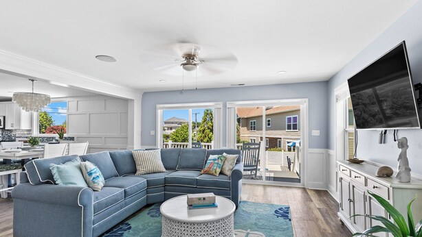 A modern living room with a sectional sofa, a round coffee table, and a flat-screen TV.