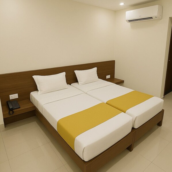 A double bed with white bedding and a mustard-colored throw.