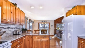 Una cocina amplia con armarios de madera, una isla central y un refrigerador grande.