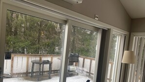 A room with a glass door leading to a snowy deck area.