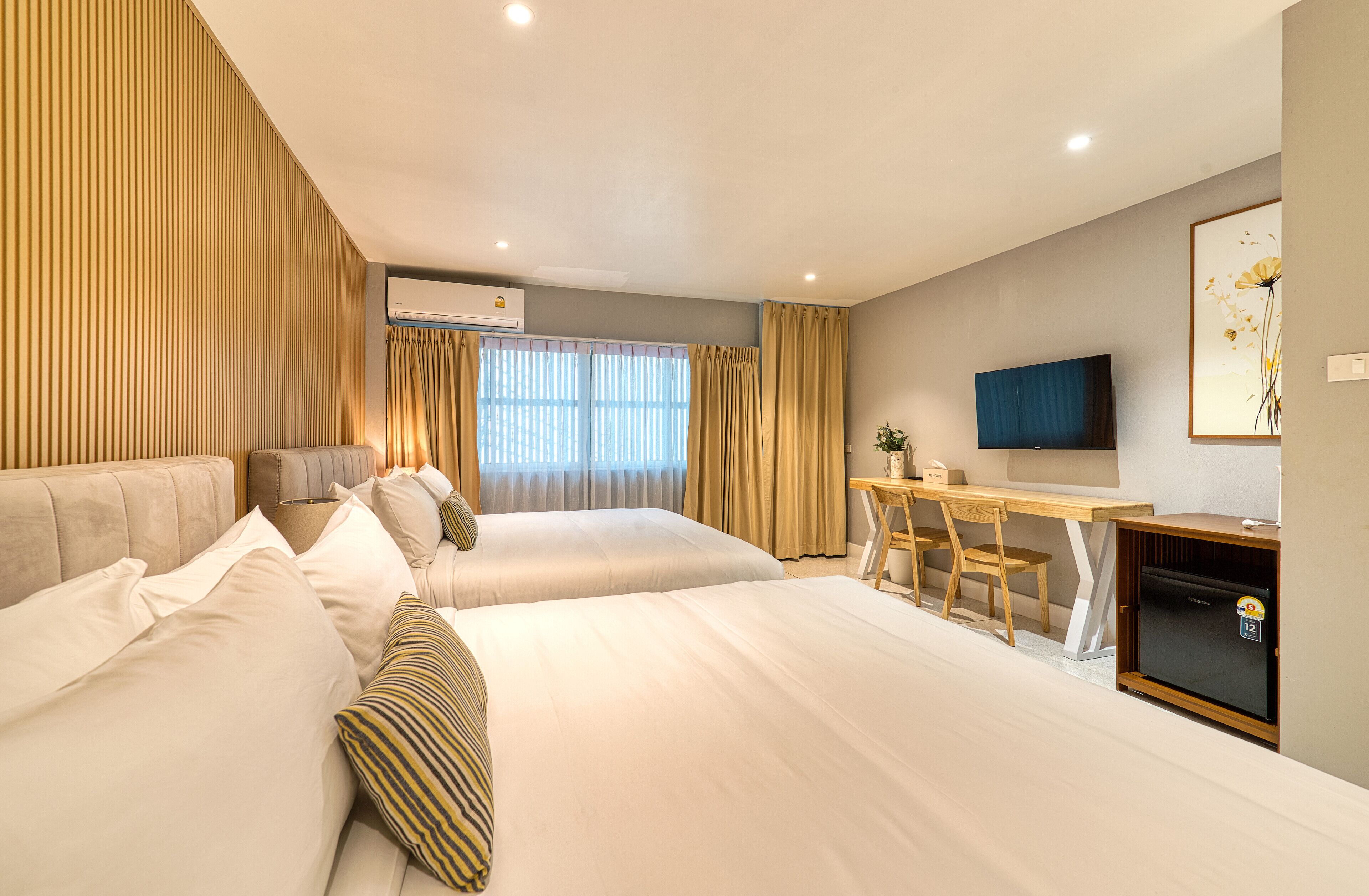 Une chambre d’hôtel avec deux lits, un bureau, une télévision et un appareil de climatisation.