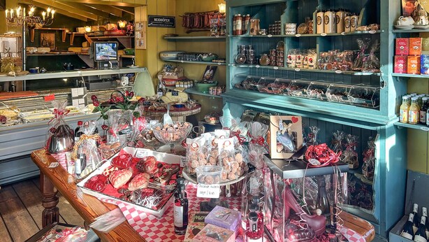 A bakery display with various baked goods and a selection of bottles.