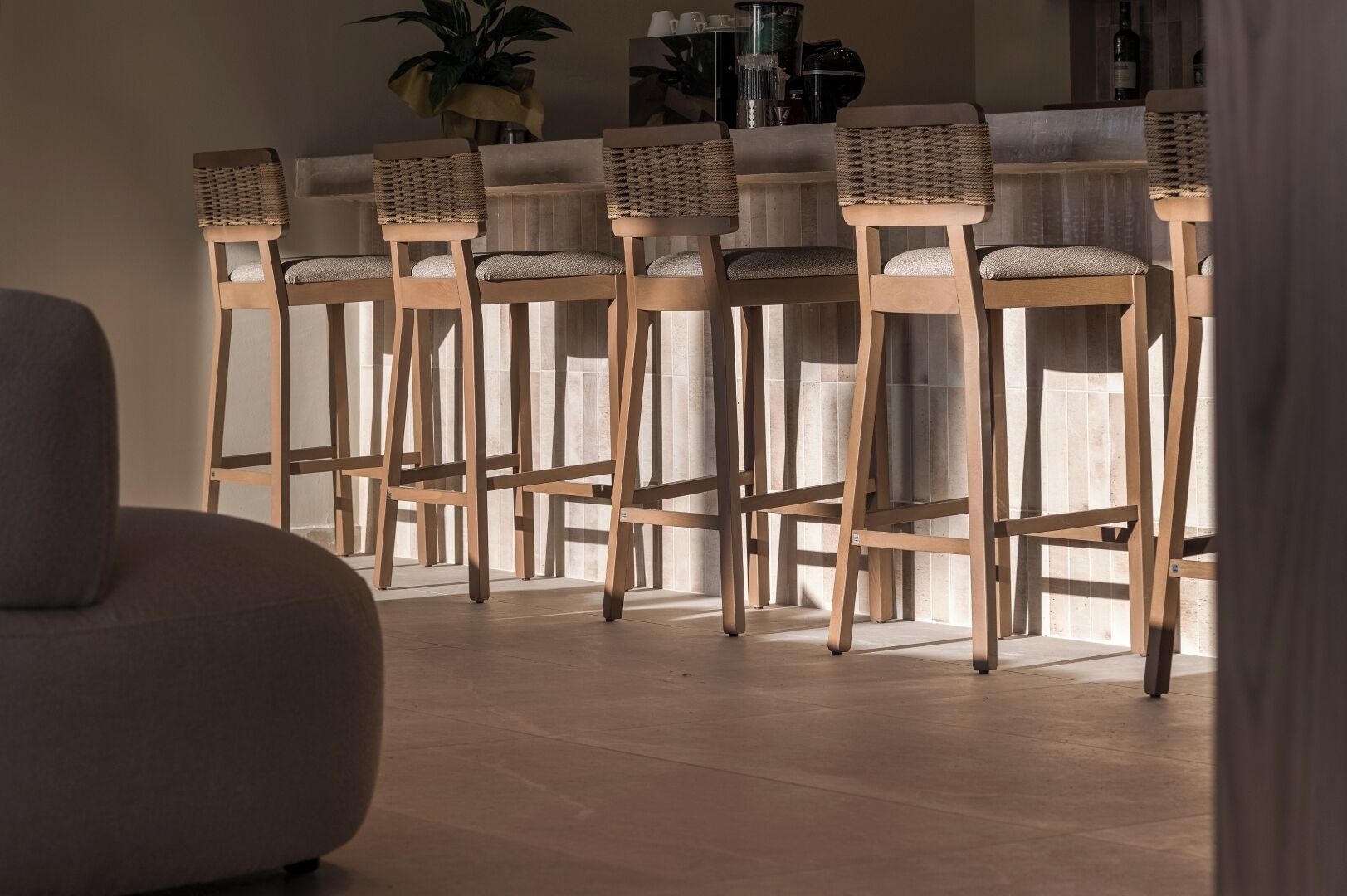 Una zona de bar con sillas de madera y un sofá.