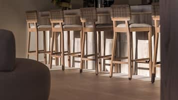 Una zona de bar con sillas de madera y un sofá.