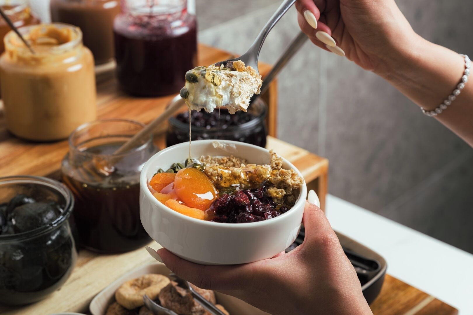 Eine Schüssel Haferflocken mit Obst und Granola, die von einer Person gehalten wird.