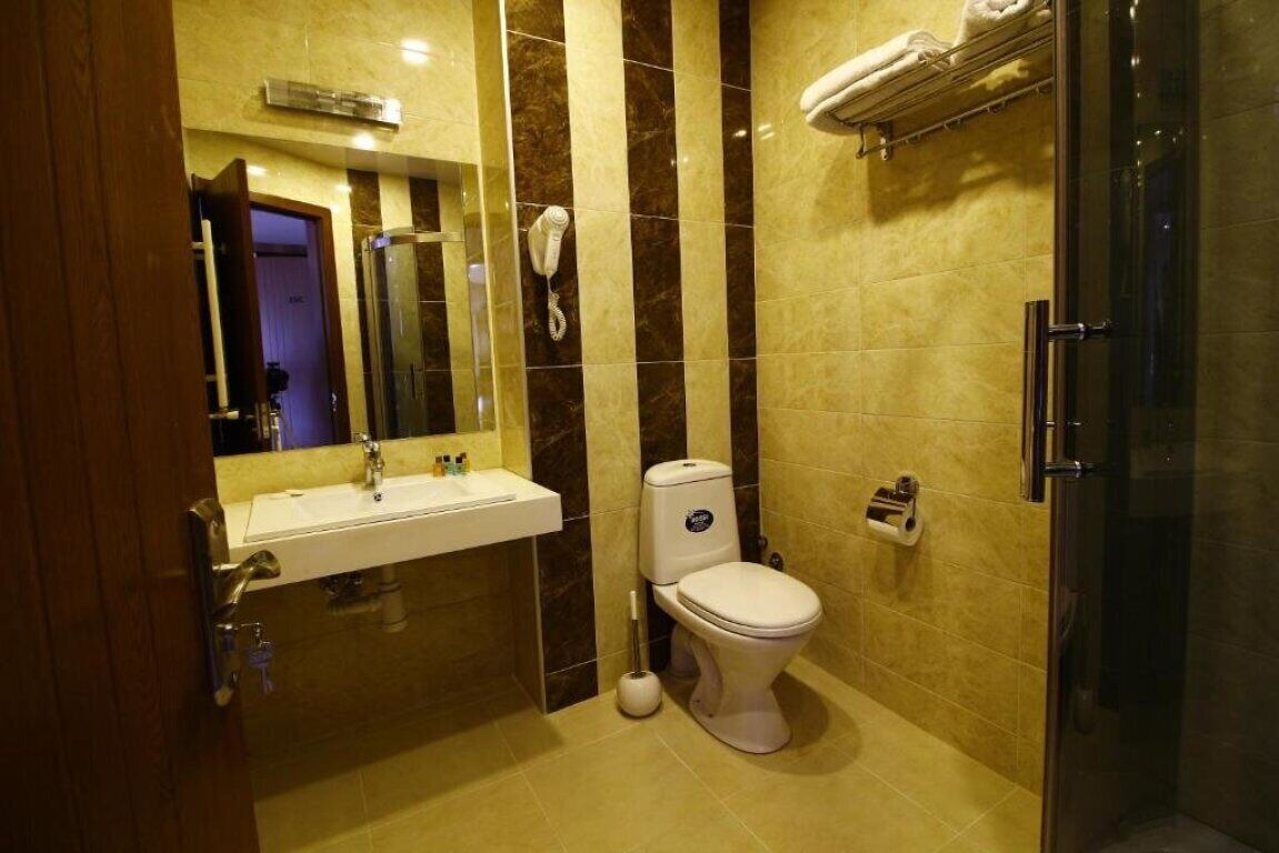 Une salle de bain moderne équipée d’un lavabo, de toilettes et d’une douche.