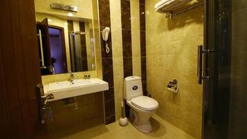 A modern bathroom with a sink, toilet, and shower.