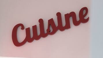 A red sign with the word "Cuisine" on a light pink background.