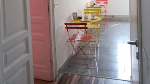 Un corridoio che conduce a una sala da pranzo, con un cartello 'Cuisine', uno scaldabagno e un cartello 'TARUMBO' appesi al muro.