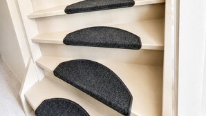 A spiral staircase with beige steps and black non-slip treads. - Coastal Inn - Private Room (Zandvoort)