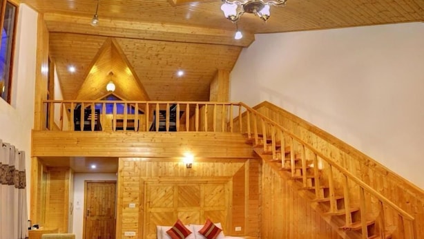 A wooden interior with a loft bedroom, a staircase, and a seating area. - Azure Chandertal Regency Hotel And Spa (Manali)
